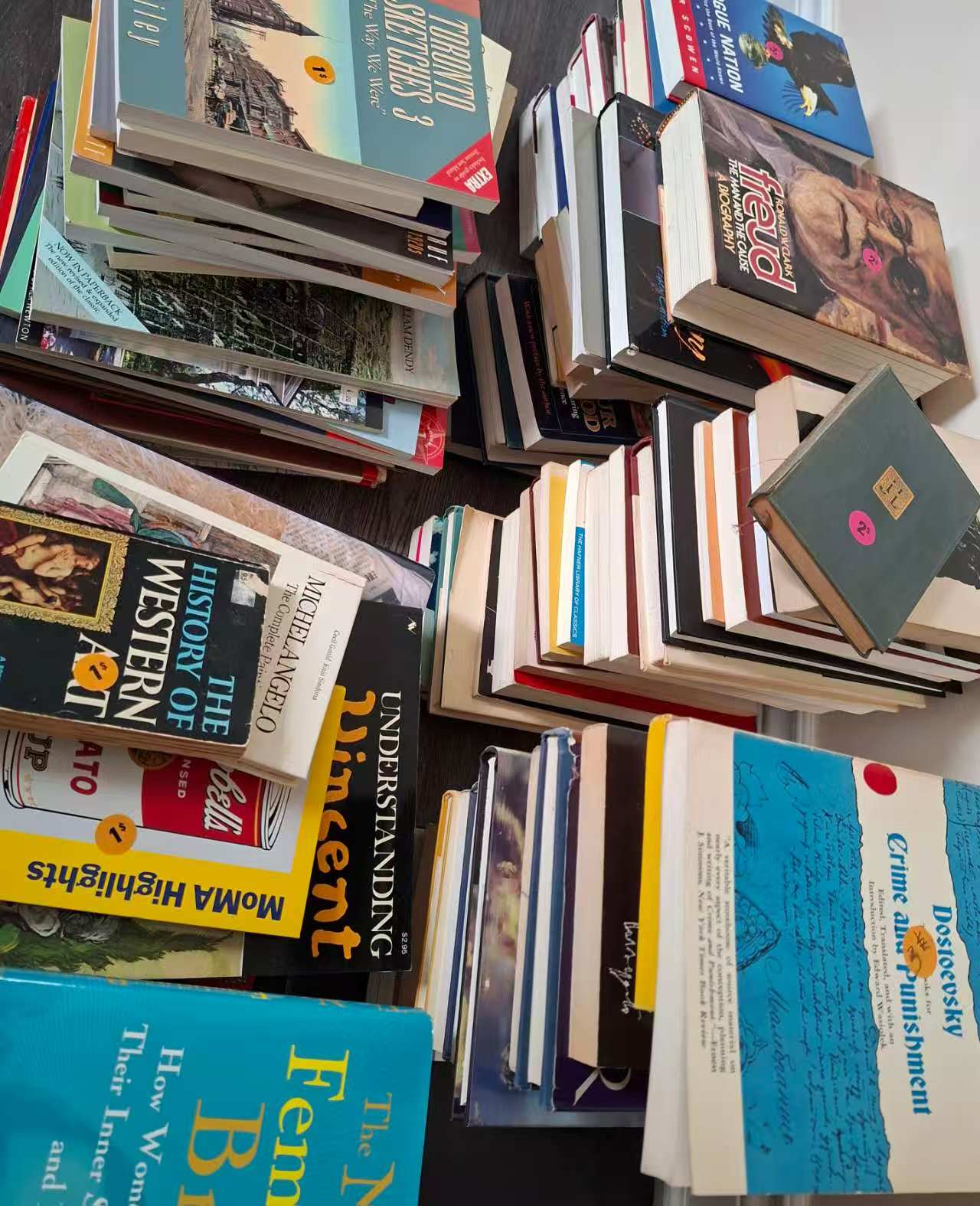 Stacks of books with colourful covers and price stickers